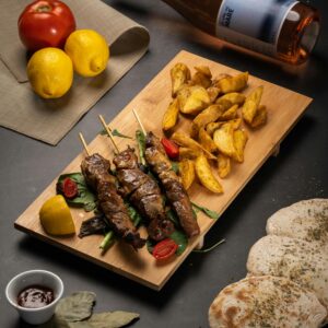 Delicious Greek souvlaki skewers with roasted potatoes and wine. Perfect for an authentic Greek dining experience.